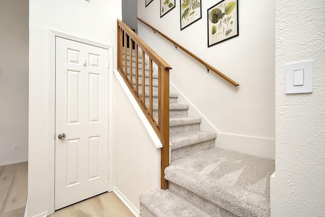 stairs featuring hardwood / wood-style floors