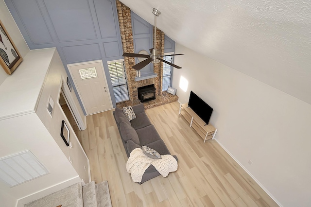 living room featuring ceiling fan, light hardwood / wood-style floors, and lofted ceiling