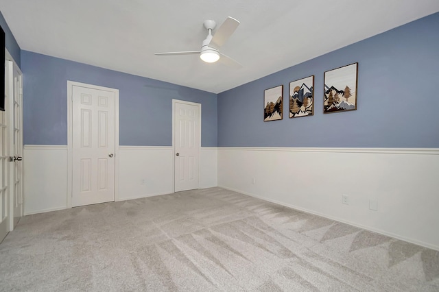 spare room featuring light colored carpet and ceiling fan