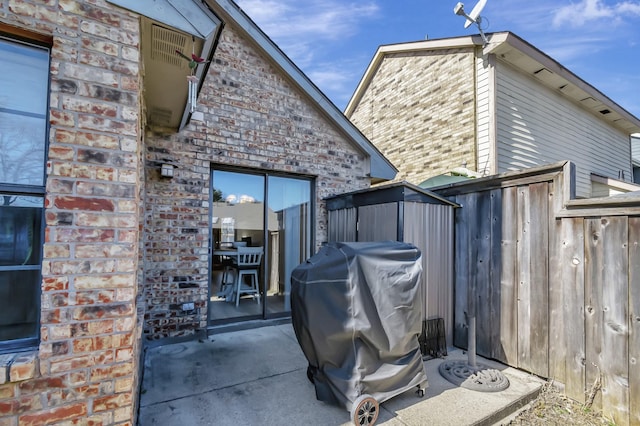 view of patio featuring area for grilling and a shed