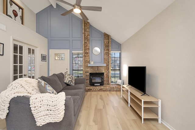 living room with light wood-type flooring, ceiling fan, high vaulted ceiling, and french doors