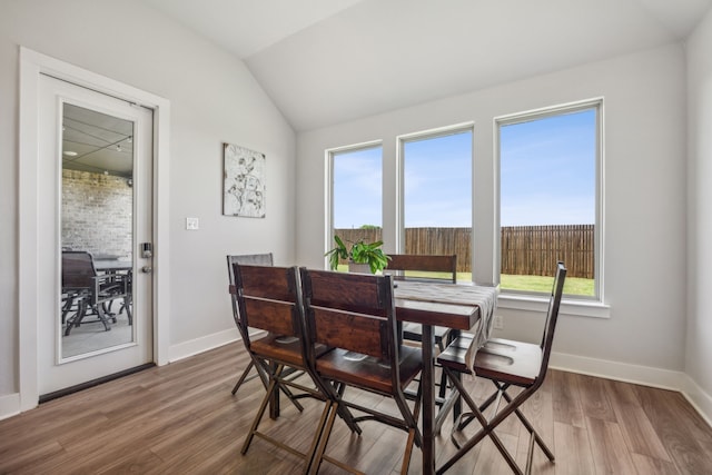 dining space with wood-type flooring and lofted ceiling