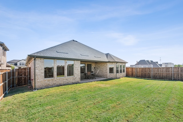 rear view of house with a patio and a yard