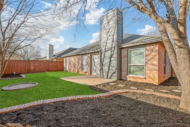 rear view of property with a lawn and a patio