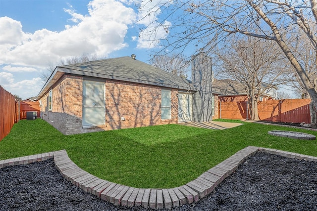 view of side of property featuring central AC unit and a lawn