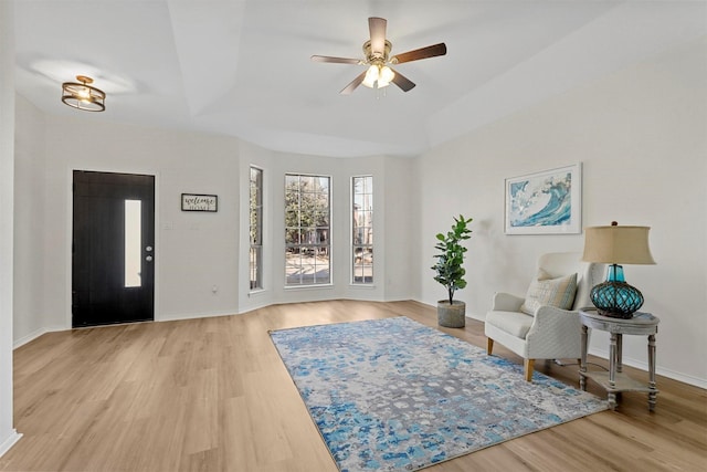 entryway featuring ceiling fan, a raised ceiling, and light wood-type flooring