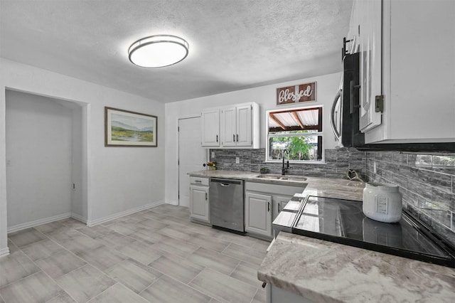 kitchen featuring appliances with stainless steel finishes, sink, white cabinetry, a textured ceiling, and decorative backsplash