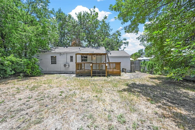 rear view of property featuring a wooden deck and a yard