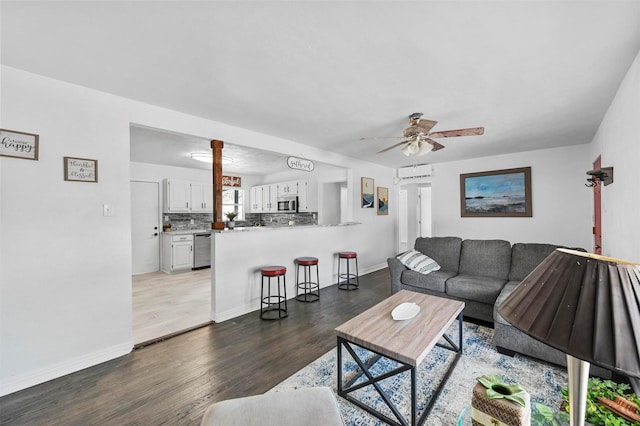 living room featuring ceiling fan and dark hardwood / wood-style floors