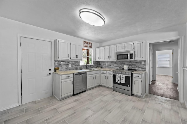 kitchen featuring sink, white cabinets, tasteful backsplash, and appliances with stainless steel finishes