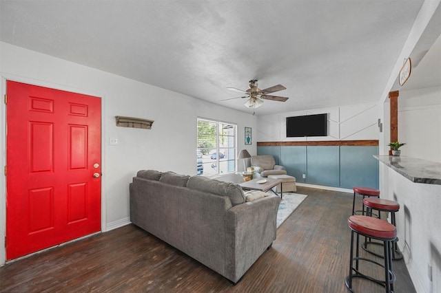 living room with ceiling fan and dark wood-type flooring