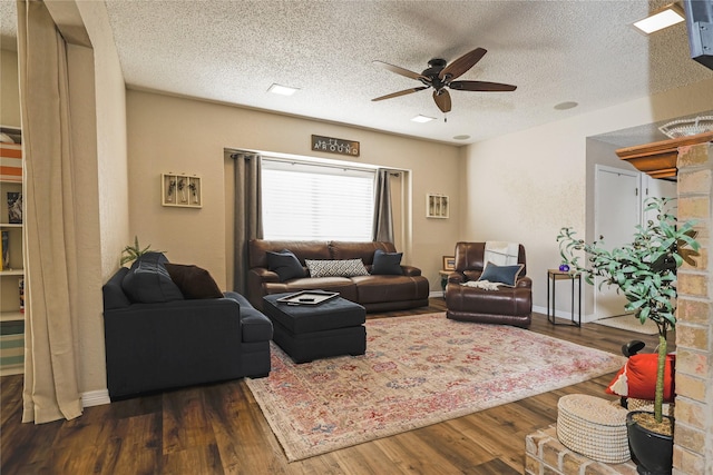 living room with a textured ceiling, dark hardwood / wood-style floors, and ceiling fan