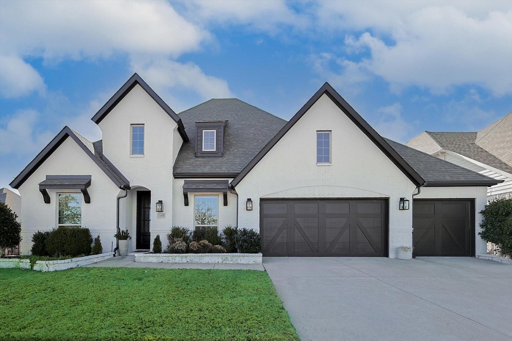 view of front of property featuring a garage and a front lawn