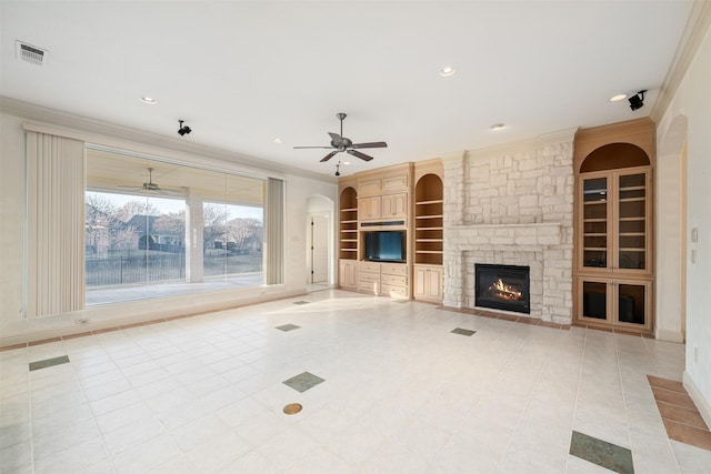 unfurnished living room with light tile patterned floors, built in features, ornamental molding, and a fireplace