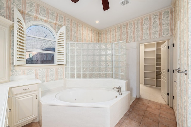 bathroom featuring tile patterned flooring, tiled bath, ceiling fan, and ornamental molding