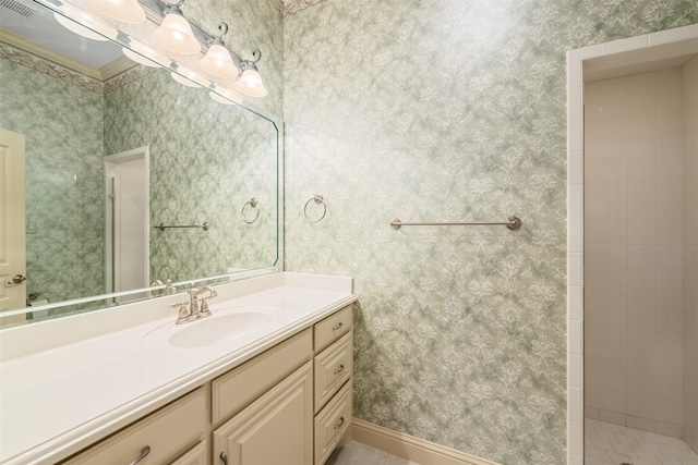 bathroom featuring a tile shower and vanity