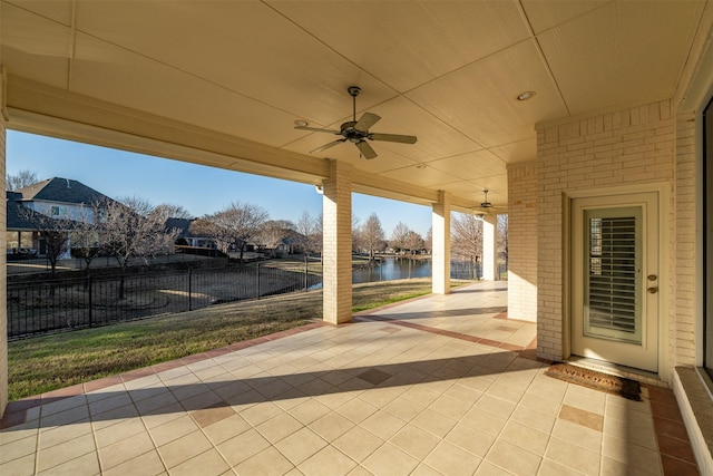 view of patio with ceiling fan and a water view