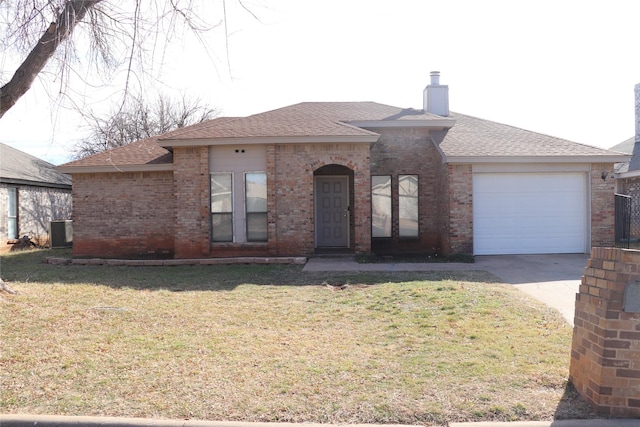 view of front facade with a garage, a front yard, and central air condition unit