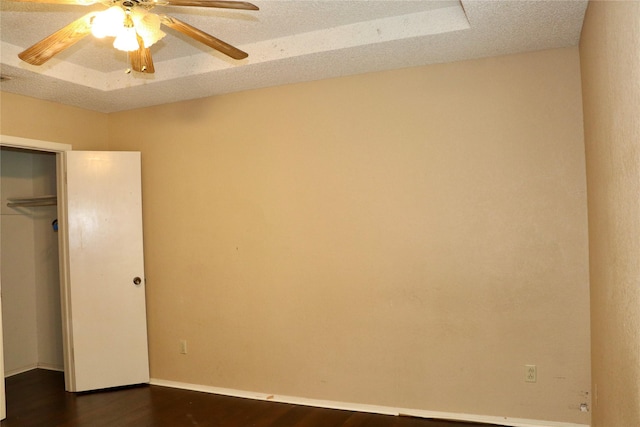 unfurnished bedroom featuring dark hardwood / wood-style flooring, a textured ceiling, a closet, and ceiling fan