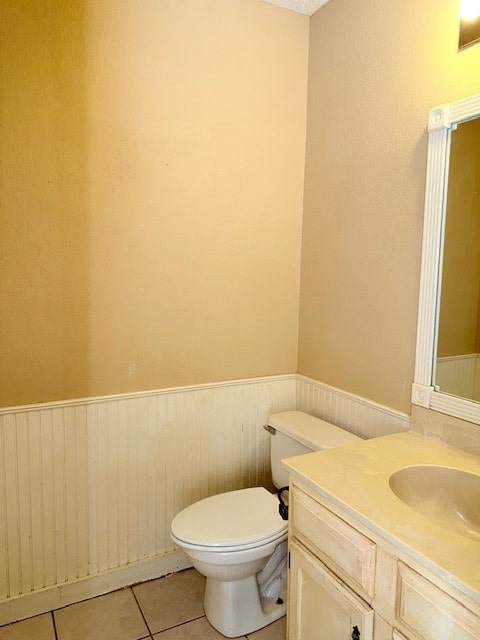 bathroom featuring vanity, a textured ceiling, tile patterned floors, and toilet