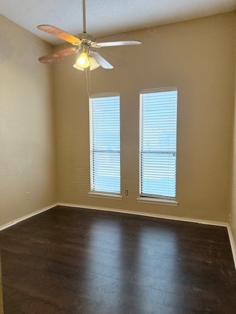 unfurnished room with dark wood-type flooring, a textured ceiling, plenty of natural light, and ceiling fan