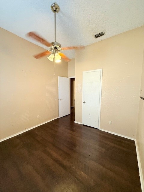 spare room with dark wood-type flooring, a textured ceiling, and ceiling fan