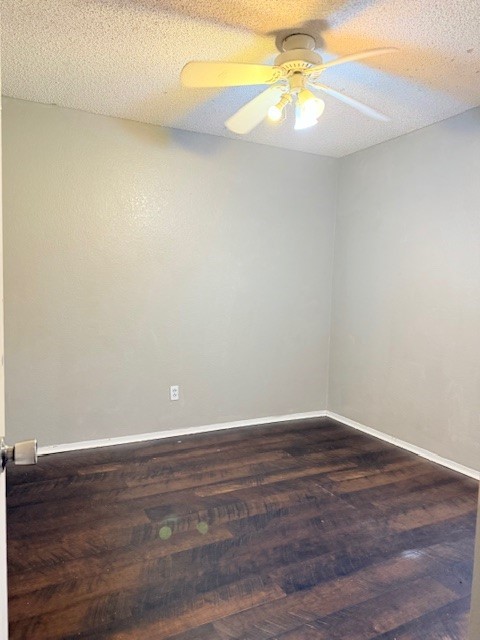 empty room featuring ceiling fan, dark hardwood / wood-style floors, and a textured ceiling