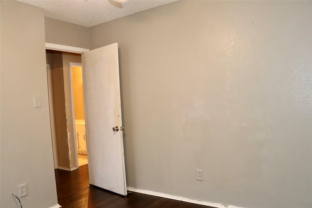 spare room with dark hardwood / wood-style floors and a textured ceiling