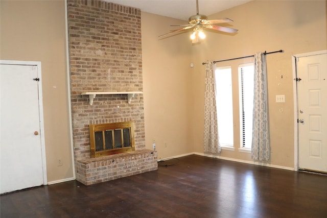 unfurnished living room with ceiling fan, dark hardwood / wood-style floors, and a brick fireplace