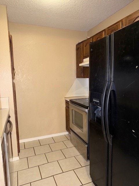 kitchen with light tile patterned floors, stainless steel range with electric cooktop, a textured ceiling, and black refrigerator with ice dispenser