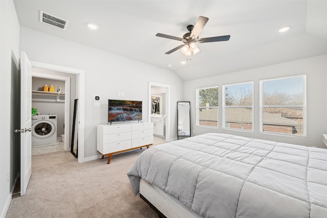 carpeted bedroom with washer / dryer, ensuite bath, a walk in closet, a closet, and ceiling fan