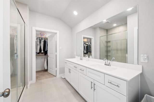 bathroom with vanity, a shower with shower door, tile patterned floors, and lofted ceiling