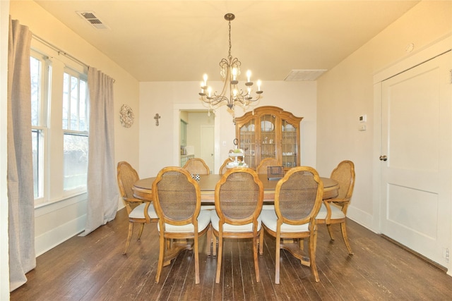 dining room featuring dark wood-type flooring and an inviting chandelier