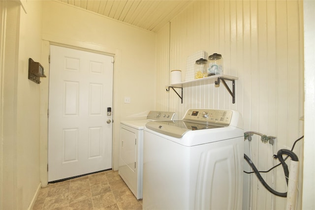 laundry area featuring separate washer and dryer, wood ceiling, and wooden walls