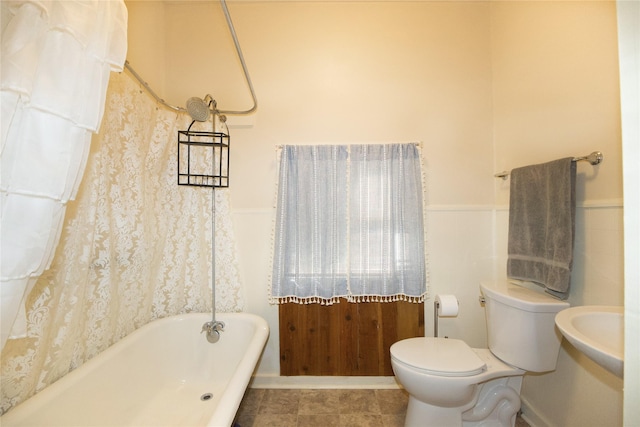 bathroom with a washtub and toilet