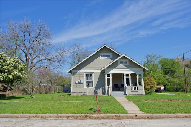 bungalow-style house featuring covered porch, a trampoline, and a front lawn