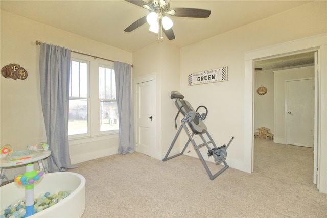 workout room featuring light carpet