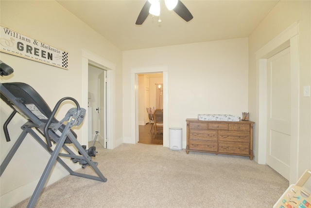 workout area featuring ceiling fan and light carpet