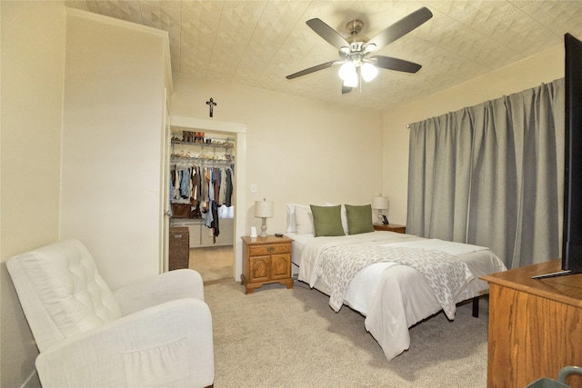 carpeted bedroom with ceiling fan, a spacious closet, and a closet