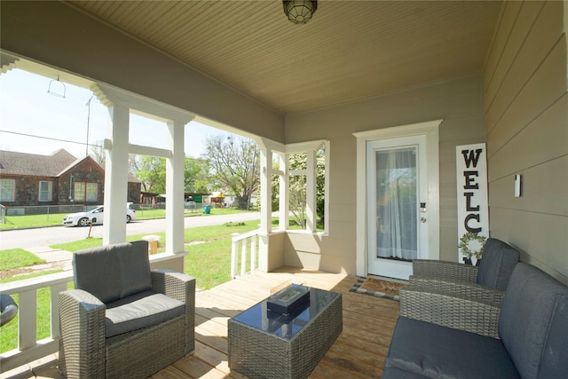 wooden deck with covered porch and an outdoor hangout area