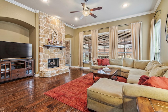 living room with a stone fireplace, ornamental molding, and dark hardwood / wood-style floors