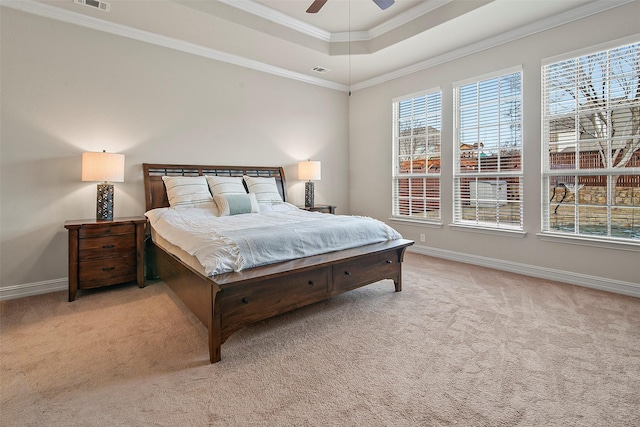 carpeted bedroom featuring ceiling fan, a raised ceiling, and ornamental molding