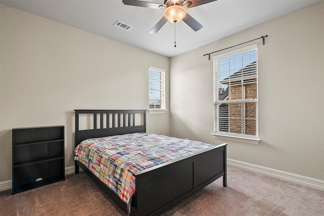 carpeted bedroom with ceiling fan and multiple windows