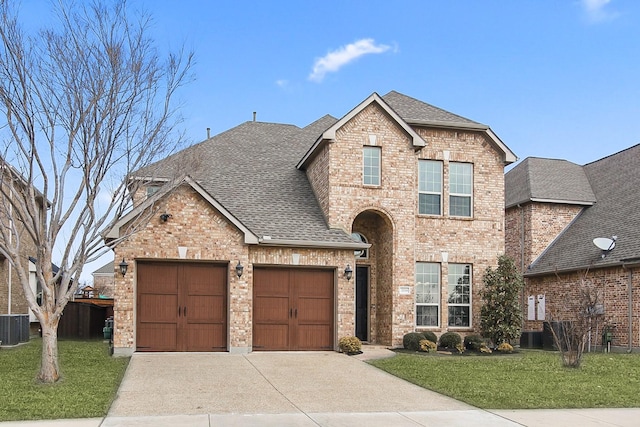 view of front of house featuring a garage, cooling unit, and a front lawn