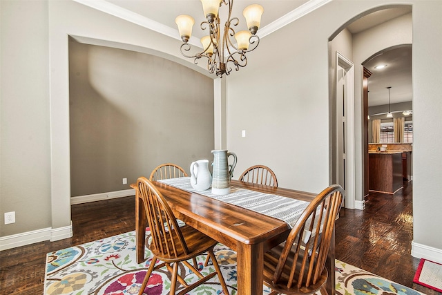 dining area with dark wood-type flooring, crown molding, and a chandelier