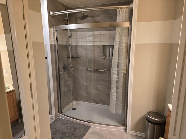 bathroom featuring tile patterned flooring, an enclosed shower, and vanity