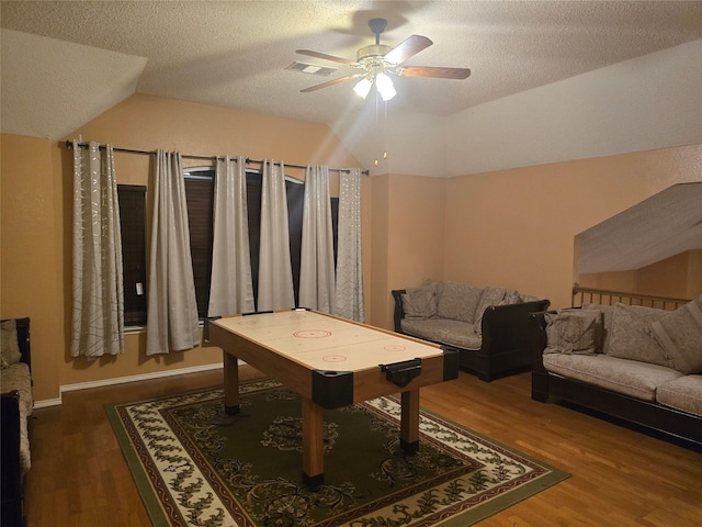 recreation room featuring ceiling fan, hardwood / wood-style flooring, a textured ceiling, and lofted ceiling