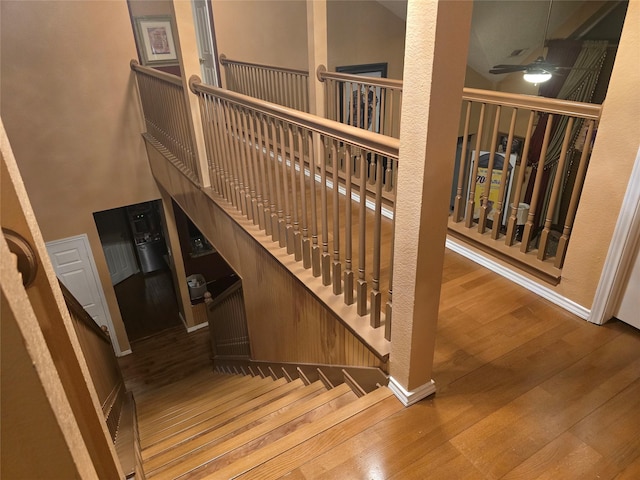 stairway featuring hardwood / wood-style flooring and ceiling fan