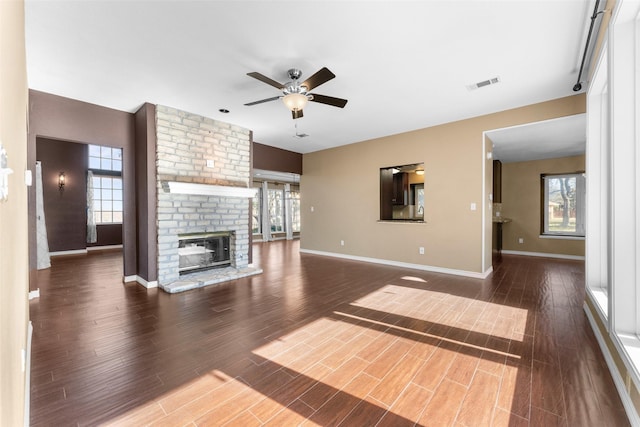 unfurnished living room featuring ceiling fan, dark hardwood / wood-style floors, and a fireplace