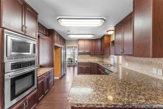 kitchen featuring sink, dark stone countertops, appliances with stainless steel finishes, and decorative backsplash